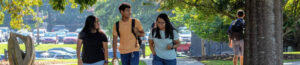 Three students walking across campus together